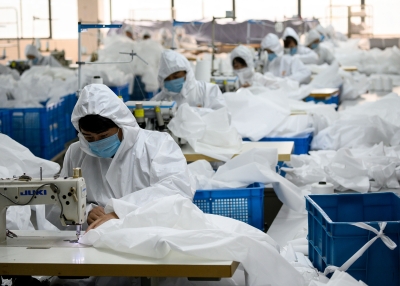 Workers, sewing, at a factory making hazardous material suits to be used in the COVID-19 pandemic.